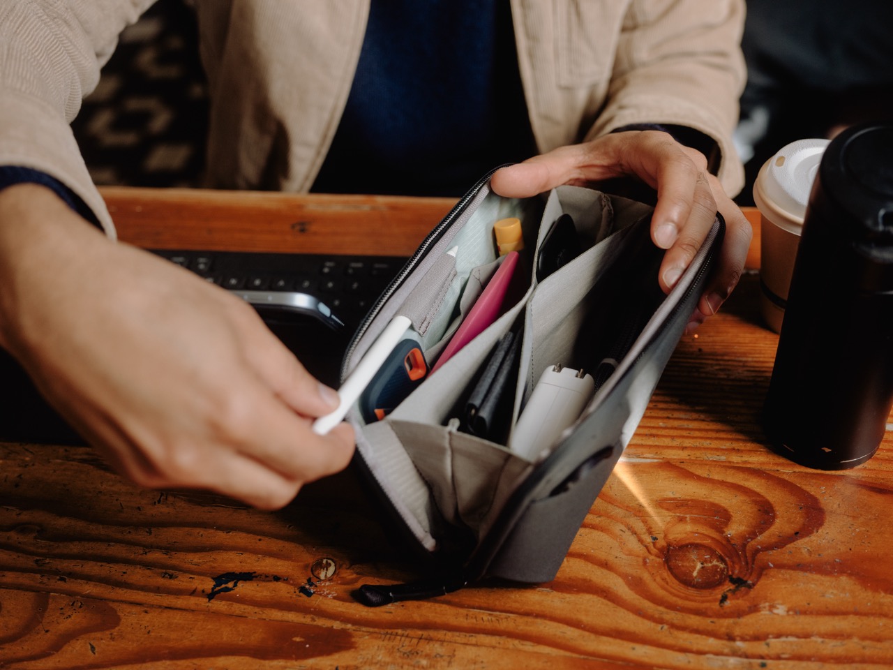 Peak Design Tech Pouch Small in der Farbe Schwarz, Lifestyle Foto mit der Tasche geöffnet auf einem Tisch