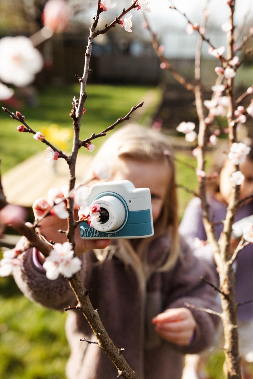 Hoppstar Expert Kamera mit Yale (blau/weiß) Silikonhülle, Lifestyle Foto mit Kind im Garten
