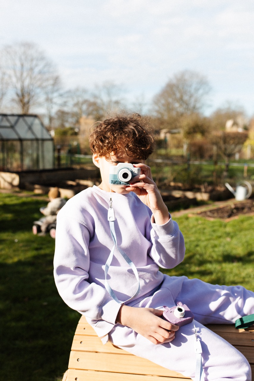 Hoppstar Expert Kamera mit Laurel (grün/weiß) Silikonhülle, Lifestyle Foto mit Kind im Garten